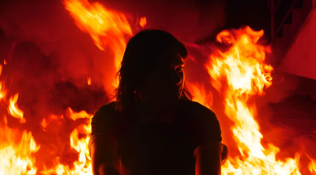 a woman arsonist in a blazing fire